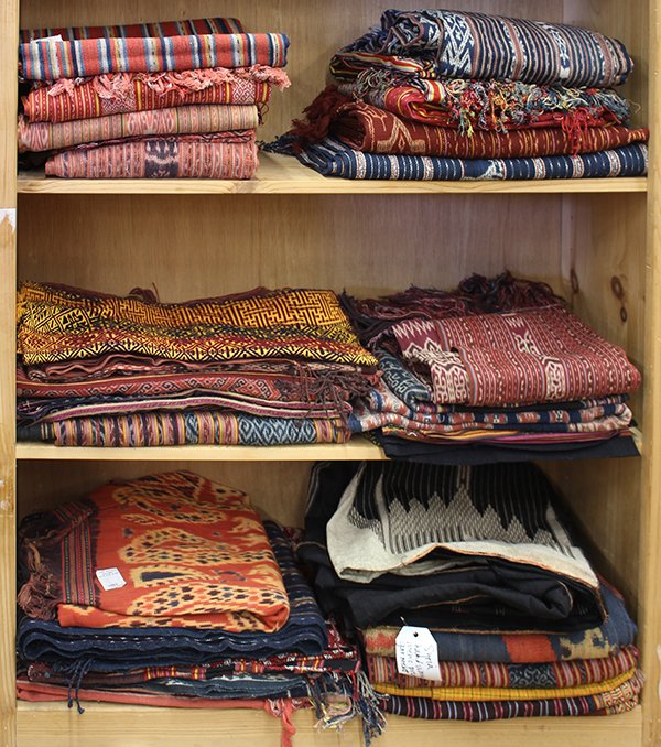 (lot of 27) Three shelves of ethnographic textiles: (lot of 27) Three shelves of ethnographic textiles, including Indonesian cotton ikats, and embroideries together with Syrian clothing. Provenance: From the estate of Edward Gerber