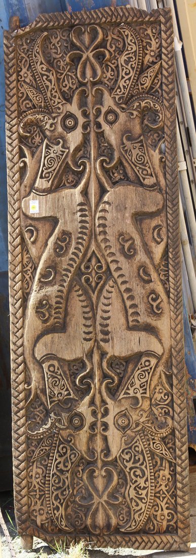 Indonesian relief carved scenic panel: Indonesian relief carved scenic panel, depicting a stylized mythological animal, the horns decorated with repeating geometric designs, 64"h x 24"w. Provenance: From the estate of Edward Gerber