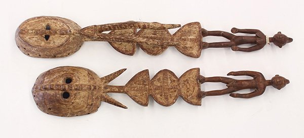 Burkina Faso style carved wood horned masks: (lot of 2) Burkina Faso style carved wood horned masks surmounted by male and female figures standing on shaped planks, largest" 42"l. Provenance: From the estate of Edward Gerber