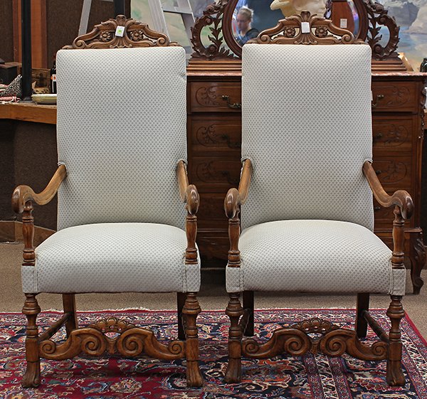 Pair of Jacobean style hall chairs: Pair of Jacobean style hall chairs, circa 1890, each having a carved crest accented with rosette medallions, surmounting the padded back, the arms with turned returns, and rising on turned legs conjoi