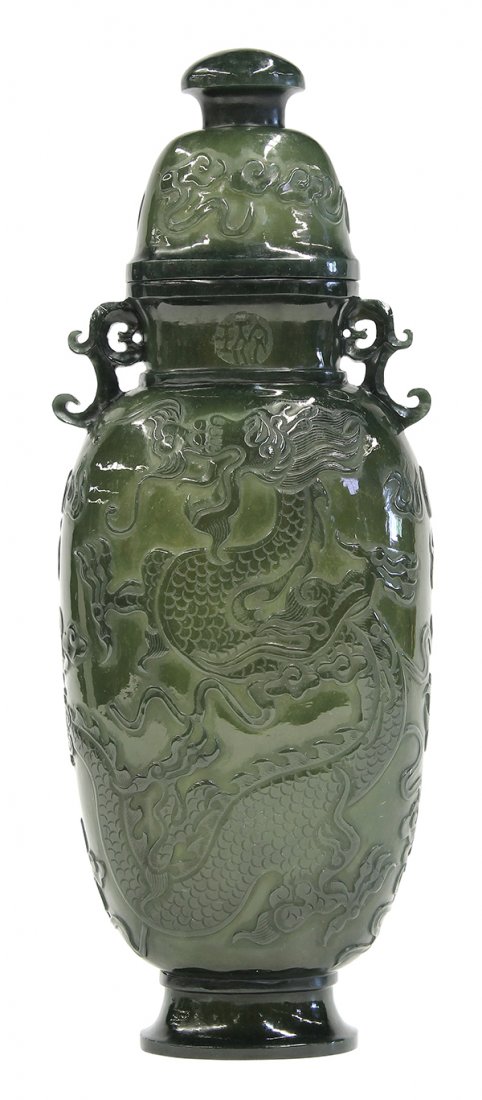 Chinese Spinach Jade Urn: Chinese spinach jade covered urn, of flattened ovoid form relief, carved with a pair of meandering dragons, the short neck with an apocryphal Qianlong mark flanked by scroll handles, the domed lid acc
