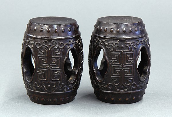 Two Miniature Wood Drum Stools: Pair of Chinese zitan wooden miniature drum stools, the upper and lower with raised bosses accenting a scroll pattern carved in relief framing the melon form apertures, 4"h