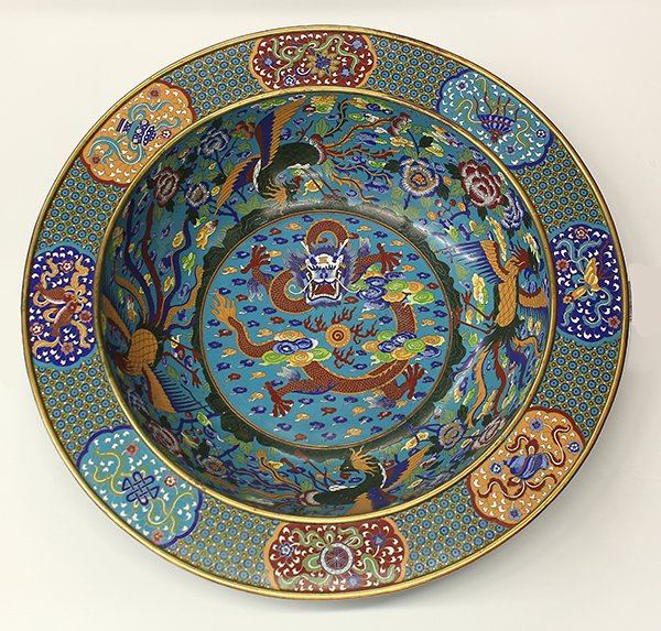 Chinese Large Cloisonne Charger: Chinese massive cloisonne enameled charger, the well centered with a meandering dragon, the interior sides with phoenix and peonies, and the everted rim decorated with Buddhist Treasures, 28.25"w. Pro