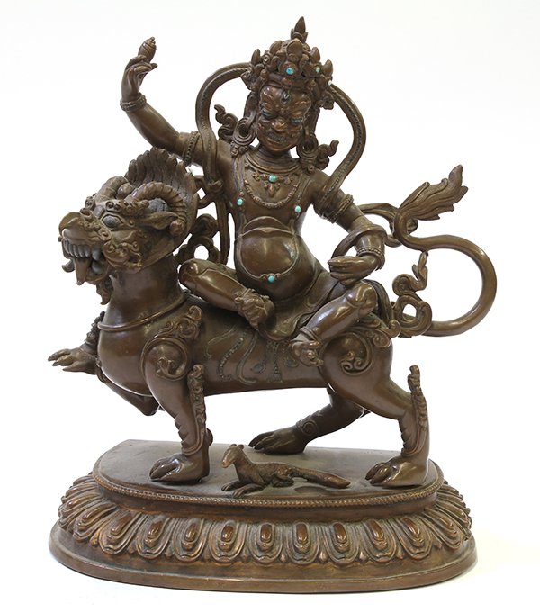 Himalayan Buddhist Figure: Himalayan copper alloy Buddhist sculpture, with a wrathful deity holding a conch shell seated on a mythical beast, heightened with turquoise colored inlay, 10.5"h. Provenance: From the estate of Edwar