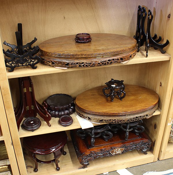 Three Shelves of Chinese Stands: (lot of 19) Three shelves of assorted Chinese wood stands, including plate stands, footed stands, and large plinths, largest: 20.25"w. Provenance: From the estate of Edward Gerber