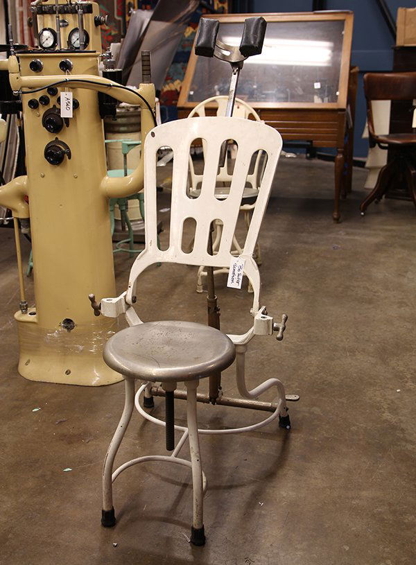 Vintage dental chair, executed in white painted metal,: Vintage dental chair, executed in white painted metal, having a hinged reclining back, with foot pump, continuing to a chrome circular seat, 47"h x 20"w x 26"d. Provenance: Deaccessioned from the coll