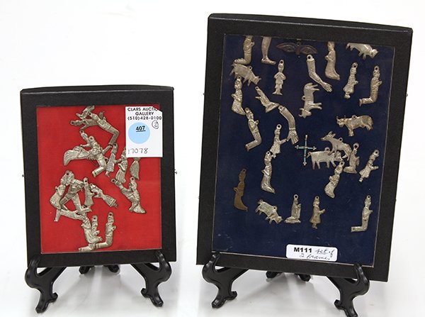 Two shadow boxes displaying assorted Asian mixed metal: Two shadow boxes displaying assorted Asian mixed metal charms including praying figures and ox