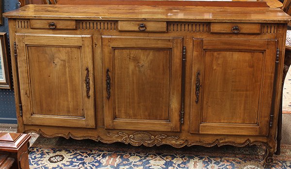 French Provincial sideboard: French Provincial sideboard, 18th century, having a rectangular top surmounting the three drawer case alternating with reeded banding above three doors, having a carved and shaped apron, the whole ris