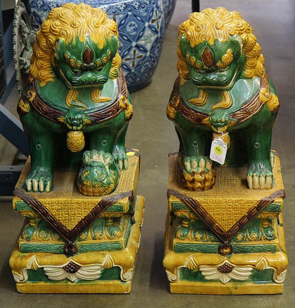 Two Chinese Ceramic Fu-lions: Pair of Chinese glazed ceramic fu-lions, with green bodies and yellow manes seated above a plinth, 23.5"h