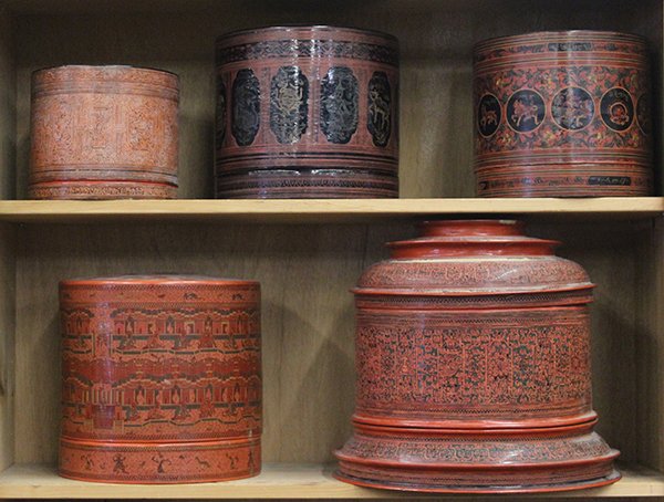 Five Burmese Lacquered Containers: (lot of 5) Two shelves of Burmese lacquered offering containers, of cylindrical form, decorated with various figural and zoomorphic motifs, 13.25"h. Provenance: From the estate of Edward Gerber