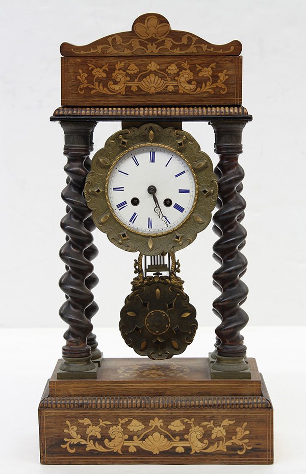 French marquetry inlaid portico clock: French marquetry inlaid portico clock, having a shaped cornice with rocaille and scroll inlay surmounting the enamel dial with Roman numerals captured in tha gilt metal collar, flanked by four ebonize