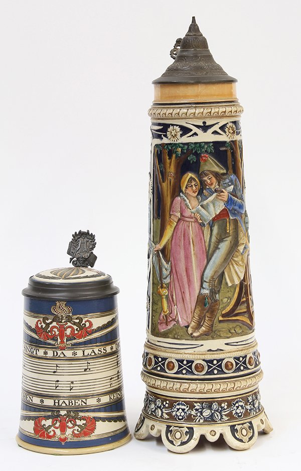 (lot of 2) German steins: (lot of 2) German steins, consisting of a Mettlach #2097, the half liter stein having etched decoration of bars of music on a slate blue ground, a porcelain inlaid lid, and a harp thumbrest, 7.5"h; to