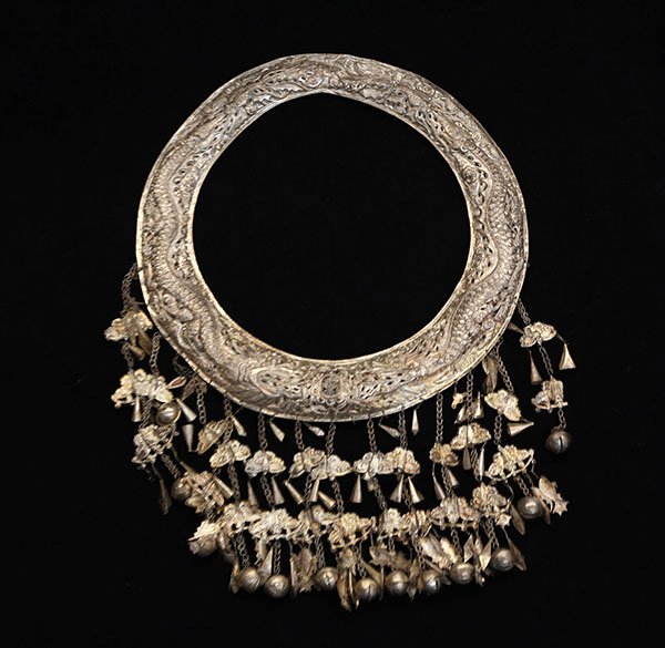Hill Tribes/Miao (Chinese Minority) necklace, the: Hill Tribes/Miao (Chinese Minority) necklace, the collar decorated with writhing chased dragons surrounded by clouds, and hung with link chains mounted with butterfly and bell charms. Provenance: From