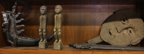 (lot of 8) Indonesian decorative wood carvings: (lot of 8) Indonesian decorative wood carvings invluding Dayak style pig sticks, one Timor sytle mask with handle, a pair of Ataoro style figures, and a Batak style figural container. Provenance: From
