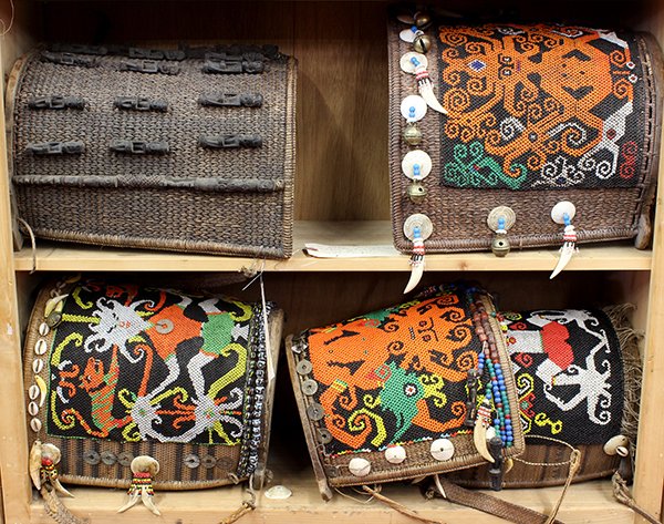Indonesian tribal baby carriers: (lot of 5) Dayak, Indonesian decorative baby carriers, made in the 20th century for trade, mostly executed in beaded basketry, possibly Dayak, each of demilune form with an intricately beaded panel de