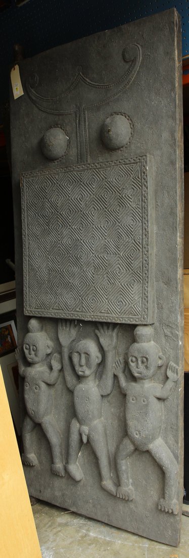 Southeast Asain carved wood door: Southeast Asian carved wood door, the decorative plank having three child figures below a tribal patterned panel and stylized female elements, 83"h x 23"w. Provenance: From the estate of Edward Gerber