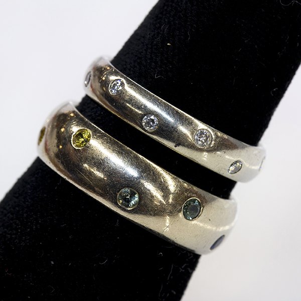 (Lot of 2) Multi-gemstone and 14k white gold bands: (Lot of 2) Multi-gemstone and 14k white gold bands including a 14k white gold 6 mm band flush set with (2) round cut rubies and various colors of round cut sapphires, size 7, together with one 3.8 mm