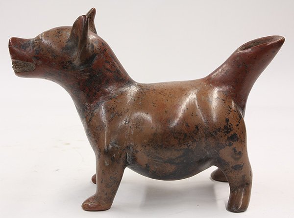 Pre Columbian, Colima figure of a dog: Pre Columbian, Colima, Mexico 200 BC - AD 250 burnished redware figure of a dog, depicted at attention, with teeth exposed, tail erect, and having a stout posture, 9.5"h x 13"w x 6"d