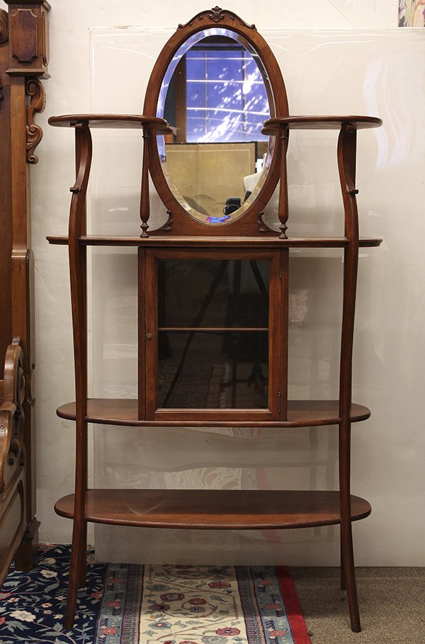 Edwardian hall stand, the carved crest above a mirrored: Edwardian hall stand, the carved crest above a mirrored back with a beveled looking glass, surmounting the lower case, having a single door, continuing to the lower tier and rising on outswept legs, 6
