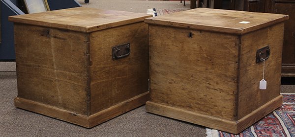 Pair of American Primitive pine storage boxes: Pair of American Primitive pine storage boxes, each having a hinged top surmounting the dovetailed case with iron handles, and rising on a molded base, 17"h x 18"w