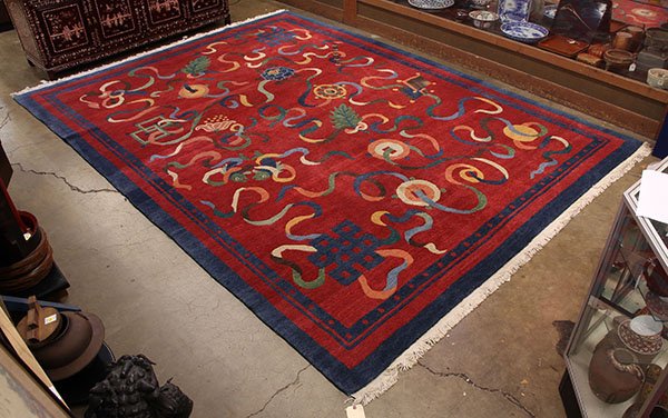 Tibetan rug having a red field with Buddhist emblems,: Tibetan rug having a red field with Buddhist emblems, 9' x 12'