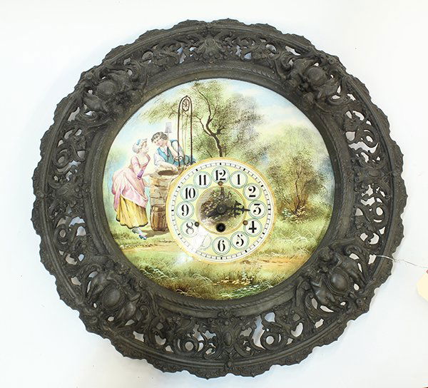 Austrian enamel wall clock: Austrian enamel wall clock, of circular form having a pierced metal figural frame with putti and griffins encasing a hand painted enamel on metal disk depicting a bucolic scene of a maid and boy at a