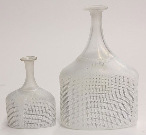 Pair of Kosta Boda art glass vases, each executed by: Pair of Kosta Boda art glass vases, each executed by Bertil Vallien, having a stick neck, executed in iridescent glass, above a rectangular base having an opalescent finish, each signed, largest: 9"h.