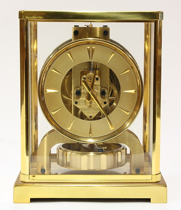 Jaeger LeCoultre Atmos clock: Jaeger LeCoultre Atmos clock, having a brass and glass paneled case, the gold circular dial with triangular stick marks, and rising on a footed base, 9"h x 7.25"w x 5"d