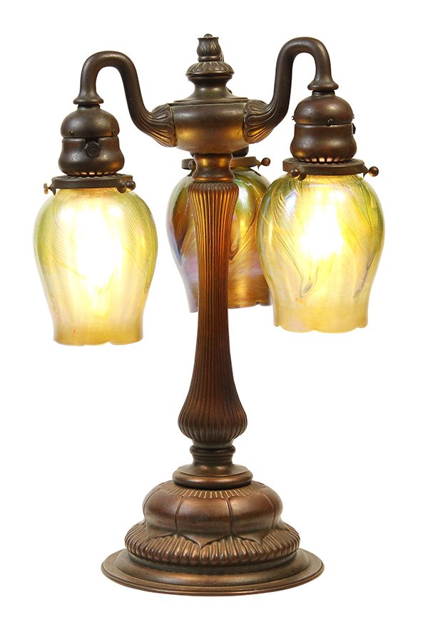 Tiffany Studios New York patinated bronze table lamp: Tiffany Studios New York patinated bronze table lamp, the three arms suspending the associated pulled feather favrile shades (unsigned, each numbered S4605, S4609 & S4622), suspended from a reeded sta