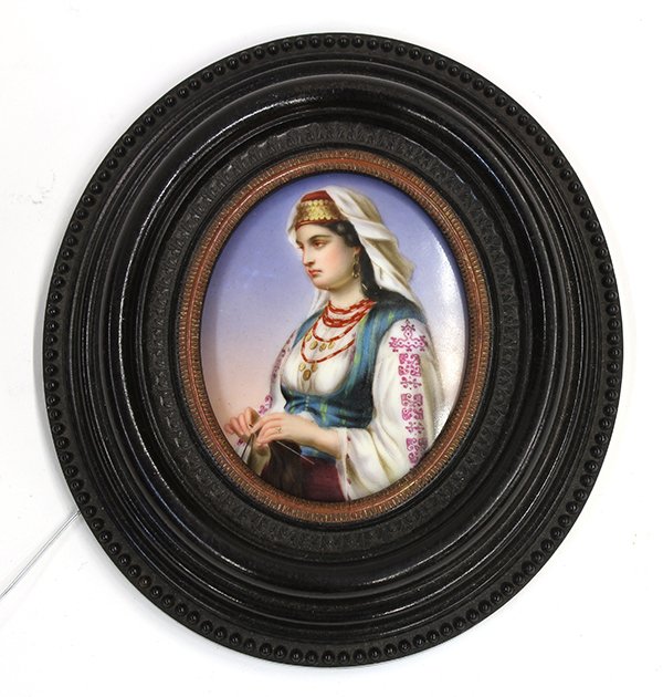 Orientalist hand painted German porcelain plaque: Orientalist hand painted German porcelain plaque, of oval form depicting a Turkish woman wearing a hat and necklace festooned with gold coins, a head scarf, and a green vest over an embroidered shirt,