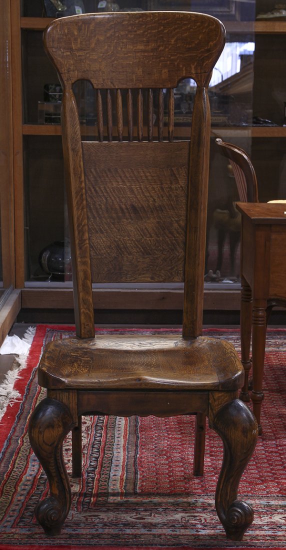 American quartersawn oak hall chair: American quartersawn oak hall chair, having a shaped crest above a spindle back, surmounting the saddle seat, and rising on outswept legs, 52.5"h x 21.5"w x 19.5"d. Provenance: Estate of Rebecca and S