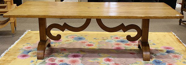 Continental style dining table: Continental style dining table, having a large plank top, above the shaped trestle base, executed in the Spanish Revival taste, 30"h x 96"w x 43.5"d