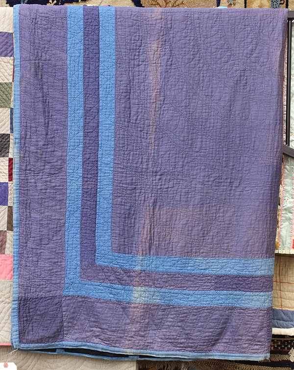 (lot of 2) American patchwork quilts: (lot of 2) American patchwork quilts, consisting of an Amish reversible open frame quilt, circa 1910, executed in muted cottons, having one side with a slate blue frame on an aubergine ground, and the