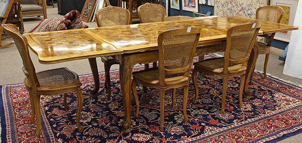 (lot of 7) French Provincial style dining suite: (lot of 7) French Provincial style dining suite, the draw leaf table having a parquetry decorated top concealing two slide out 23.5"l leaves, above the carved apron having floral sprays, rising on cab