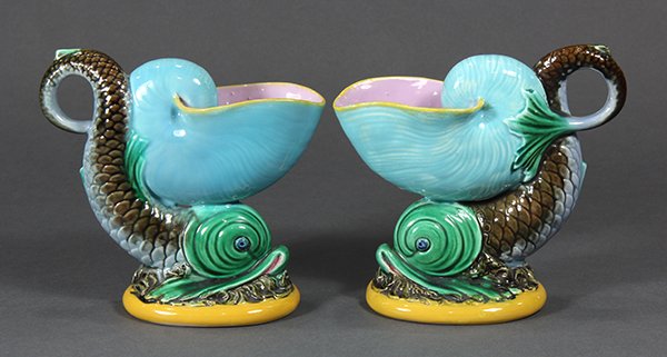 Pair of George Jones majolica shell and dolphin form: Pair of George Jones majolica shell and dolphin form diminutive pitchers, circa 1885, each modeled as a turquoise nautilus shell supported on the back of a green and brown dolphin, the tails of the do
