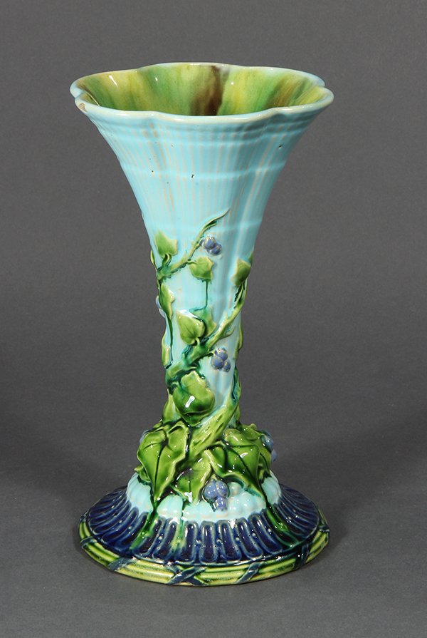 Majolica trumpet vase, having a fluted rim, the body: Majolica trumpet vase, having a fluted rim, the body glazed in robin's egg blue and twined with a molded ivy vine in emerald, the whole rising on a stepped circular foot glazed in cobalt and emerald, 