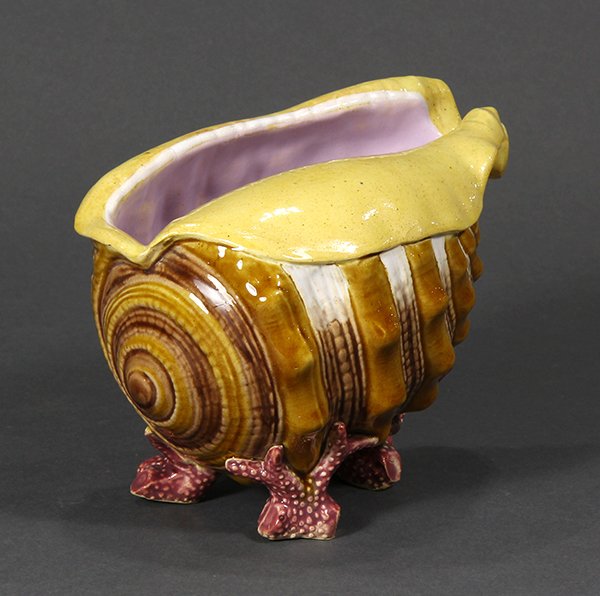 Mintons Majolica shell form footed spoon warmer,: Mintons Majolica shell form footed spoon warmer, naturalistically modeled as a conch shell supported on three short coral branch feet, date code for 1889, impressed uppercase mark, shape no. 1837 and 
