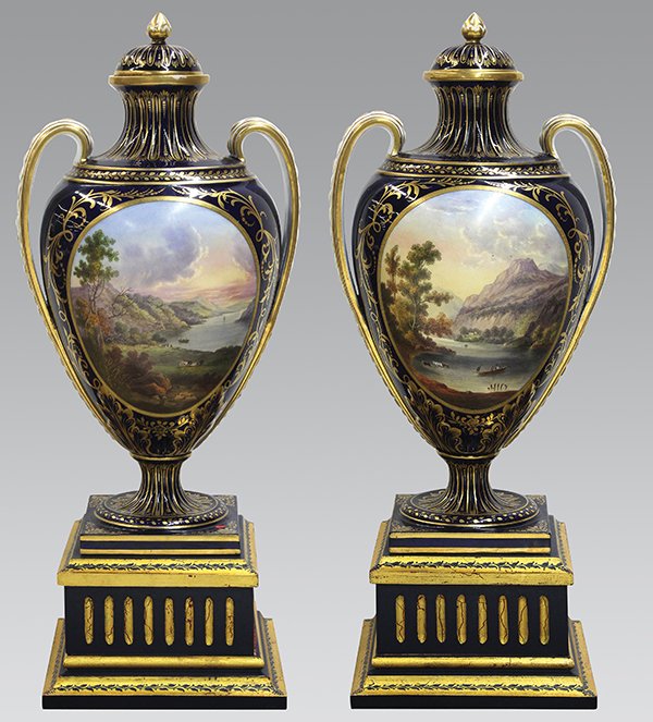 Pair of Sevres style porcelain covered urns: Pair of Sevres style porcelain covered urns, each having a cobalt body with gilt floral and vine decoration surrounding the central reserve depicting a pastoral landscape at sunset, and rising on a la
