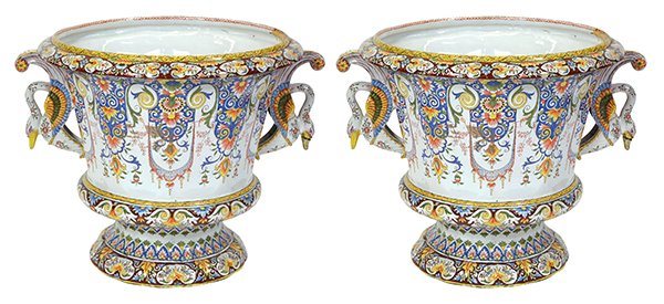 Pair of French faience polychrome decorated two handled: Pair of French faience polychrome decorated two handled urns, each having a Classical style form, painted with floral lappets, and flanked by swan handles, 16.25"h. Provenance: From the Pebble Beach,