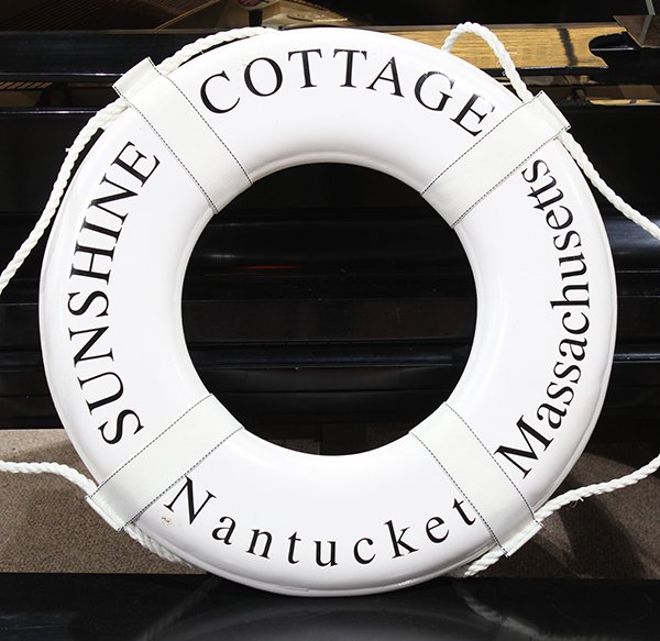 (lot of 2) Life preserver inscribed "Sunshine Cottage,: (lot of 2) Life preserver inscribed "Sunshine Cottage, Nantucket, Massachusetts", 24.5"dia.; together with a plaque having a gilt central medallion in the form of a compass reading "Nantucket Island",