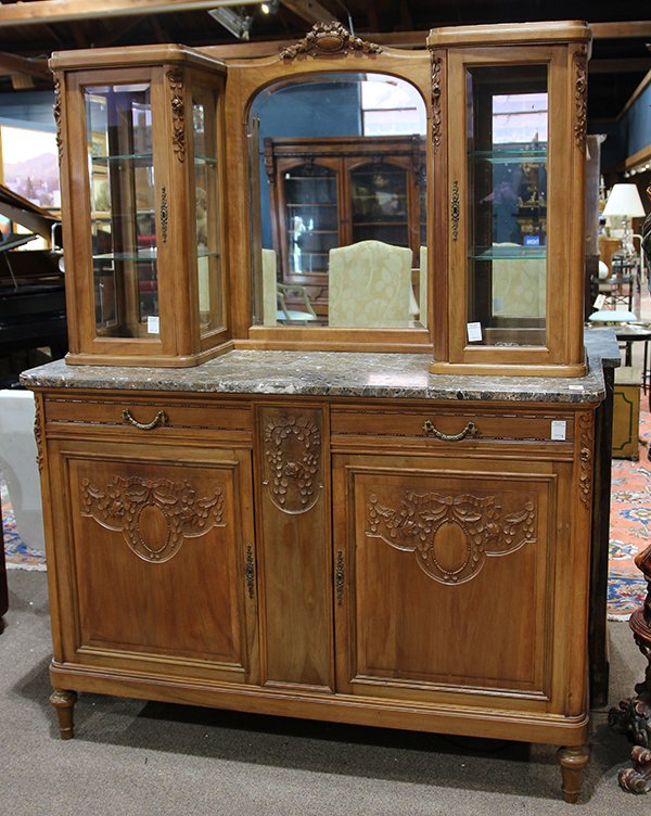 French Art Deco buffet, the mirrored superstructure: French Art Deco buffet, the mirrored superstructure flanked with two bevelled glass vitrines, surmounting the lower case retaining gilt pulls, and relief carved reserves, the whole rising on turned le