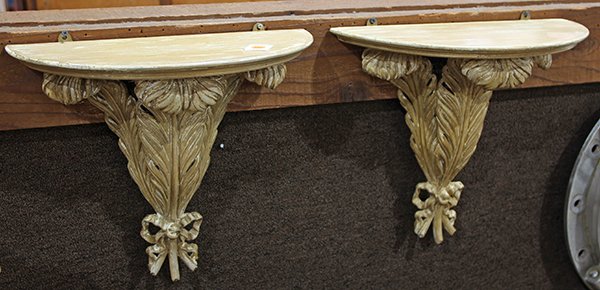 Pair of Continental style giltwood wall brackets,: Pair of Continental style giltwood wall brackets, having a demilune top, the base modeled as three feathers conjoined by the bow tie accent, 16"h x 16.5"w. Provenance: From the Nantucket, MA estate of