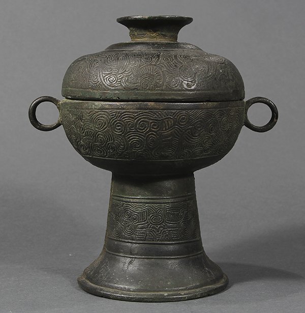 Chinese Bronze Dou Vessel: Chinese archaistic bronze dou vessel, compressed body with two ring handles, raised on a tall spreading foot, with cloud patterns to the surface, and Chinese characters to the interior of the lid, 8"h