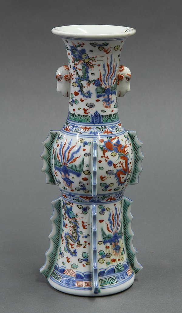 Ming Style Gu Form Vase: Ming style porcelain vase of gu form, decorated with dragons and phoenix in registers, the neck flanked by zoomorphic handles and the lower section accented by flanges, the base with an apocryphal Min