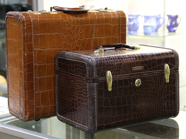 Vintage gentleman's toiletry suitcases: (lot of 2) Vintage gentleman's toiletry suitcases, executed in croco-embossed leather, and having open interiors, largest: 6"h x 15"w x 13"d.