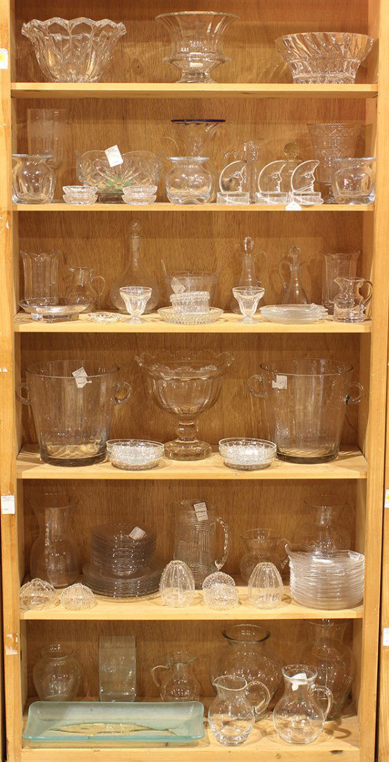 (lot of 80) Six shelves of clear crystal and glass: (lot of 80) Six shelves of clear crystal and glass table accessories, including (2) footed centerpieces, a wine carafe, a pair of ice buckets, candle holders, and (7) pitchers of various sizes, larges