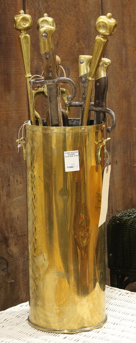 (lot of 9) Group of fireplace tools in a brass: (lot of 9) Group of fireplace tools in a brass cylindrical form stand, consisting of bellows, two sets of tongs, a poker and a shovel, one set having a sword handle, the other with turned handles; tog
