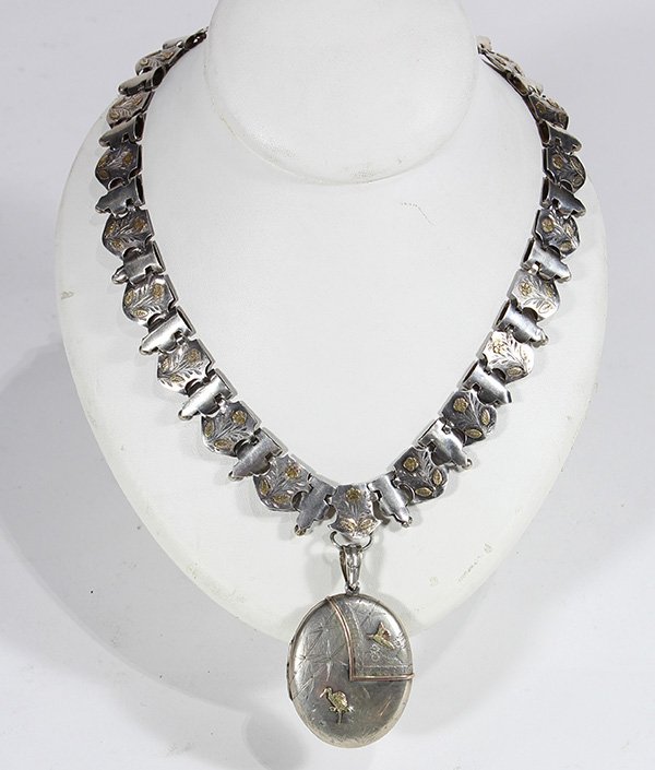 Vintage silver and mixed metal locket pendant necklace: Vintage silver and mixed metal locket pendant necklace featuring a hand engraved oval locket, possibly Japanese, with stork, song bird and trim apliques in 14k multi gold, 1 1/2" X 1 3/4", suspending 