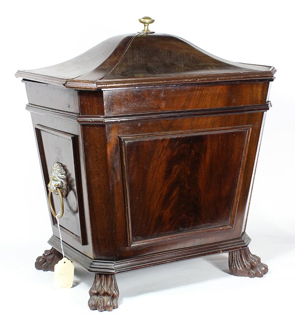 Regency mahogany cellarette, early 19th century, having: Regency mahogany cellarette, early 19th century, having a coffer form, with a brass finial above the domed lid, the paneled case flanked by handles having lion head mounts, and rising on paw feet, 21"
