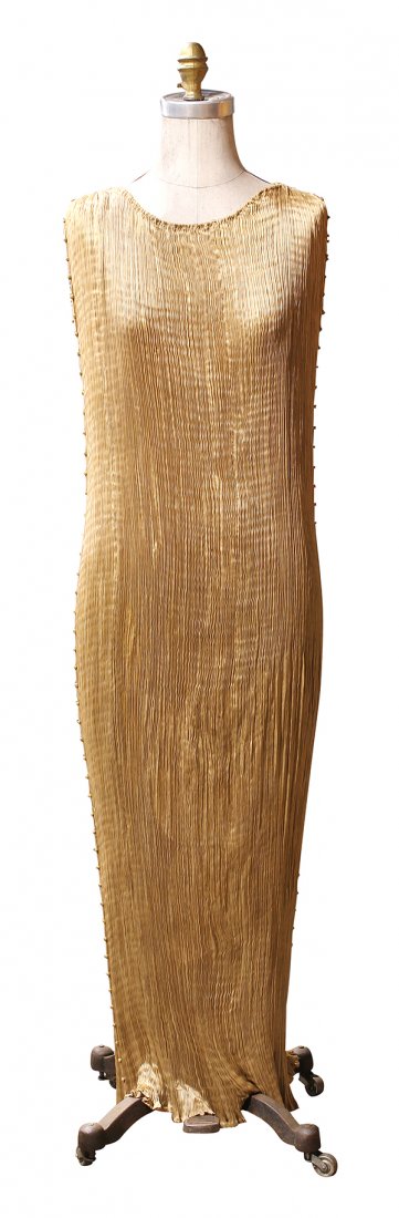 Fortuny 'Delphos' dress: Fortuny 'Delphos' dress, designed 1907, executed in pleated gold Italian silk, the full length gown having a draw-string neck line and seams finished with Venetian pate-de-verre glass beads, retaining